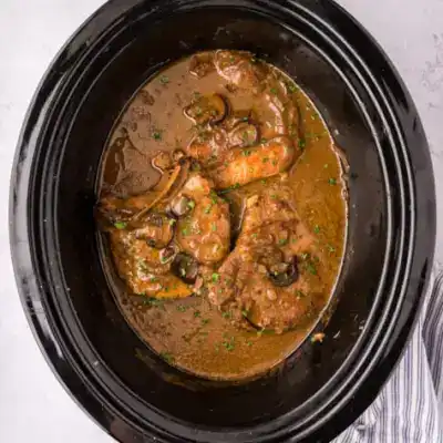 Succulent shrimp simmering in a flavorful sauce in a slow cooker.