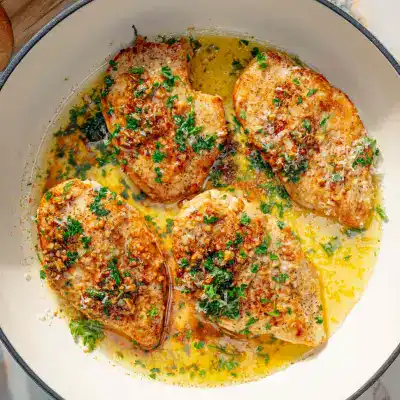 Golden baked chicken breasts in garlic butter sauce with herbs and crispy topping.