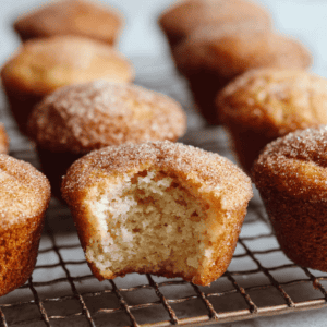 Moist vanilla cupcakes with sugar and cinnamon topping, on cooling rack, close-up.