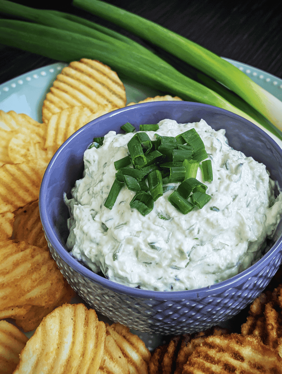 Creamy cucumber dip garnished with chopped green onions, served with potato chips and green onions. Perfect for snacks or parties.