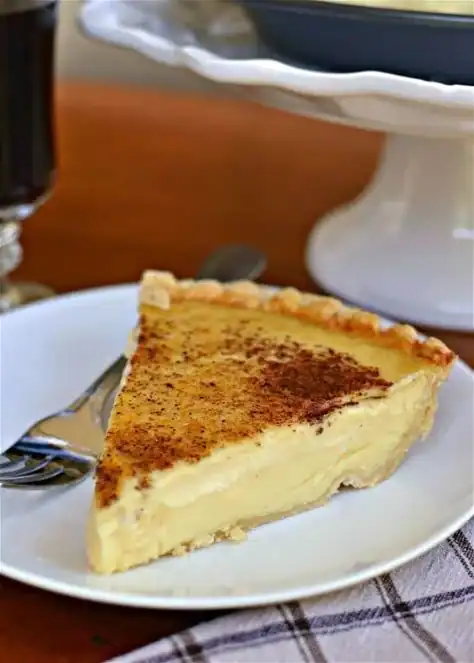 Delicious slice of old-fashioned egg custard pie on a rustic table
