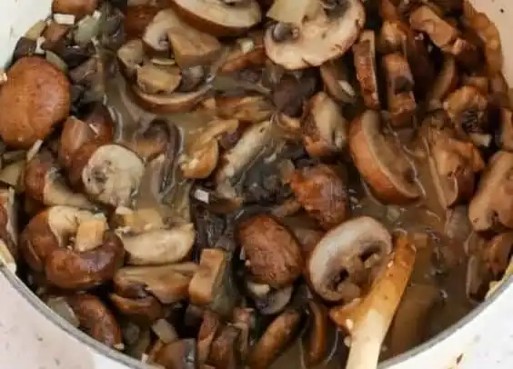Creamy mushroom soup in a bowl, garnished with fresh herbs.