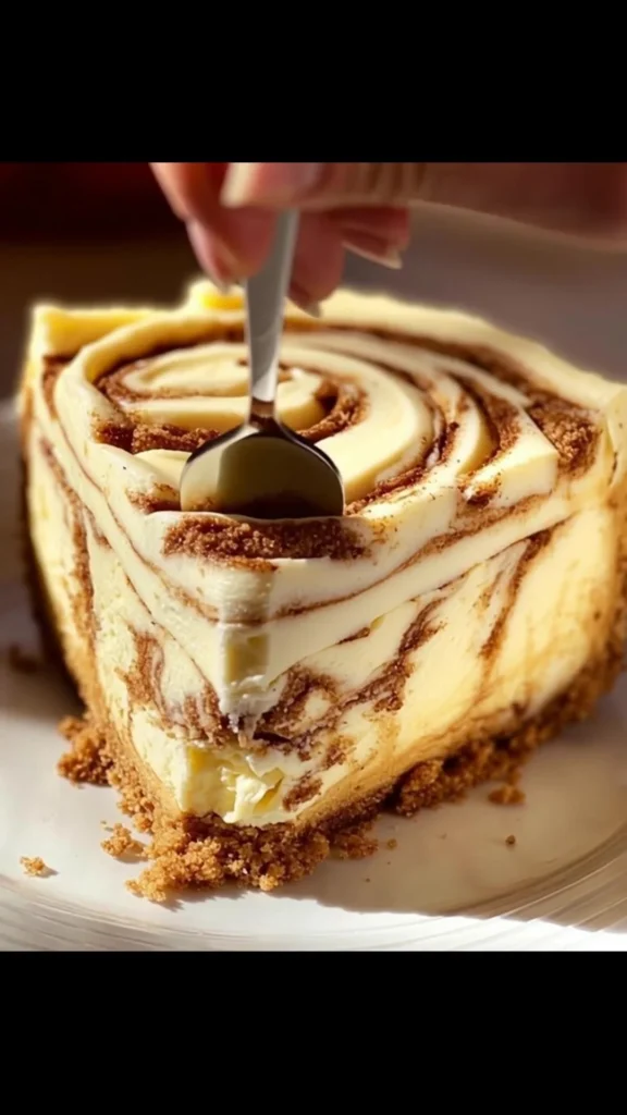 Delicious cinnamon roll cheesecake with cream and cinnamon swirls, perfect dessert