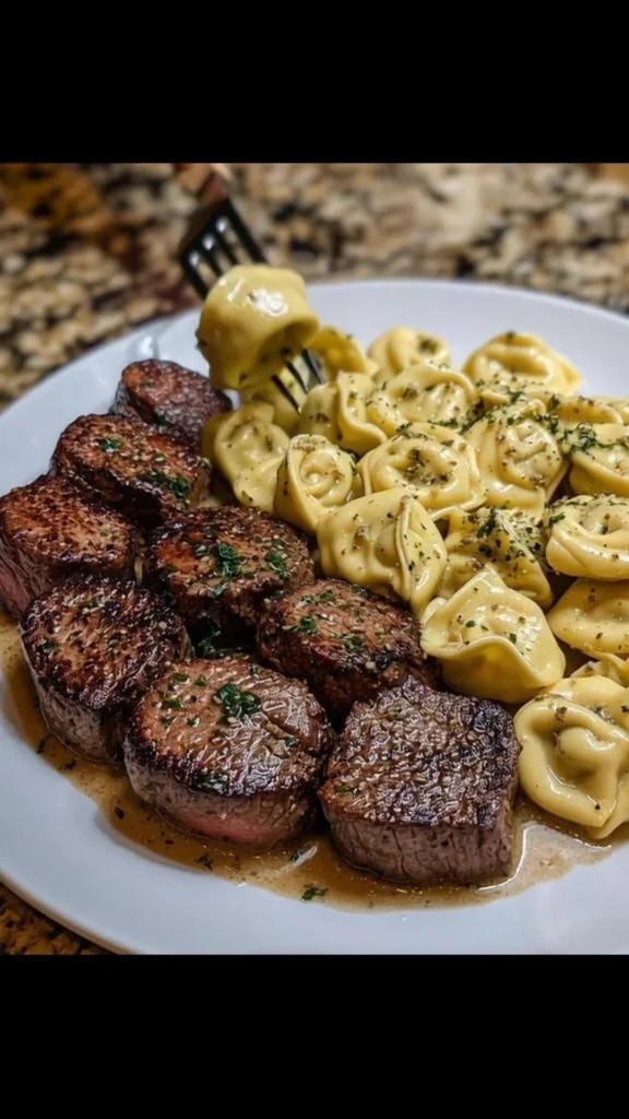 Garlic Butter Steak served with Alfredo Tortellini on a plate