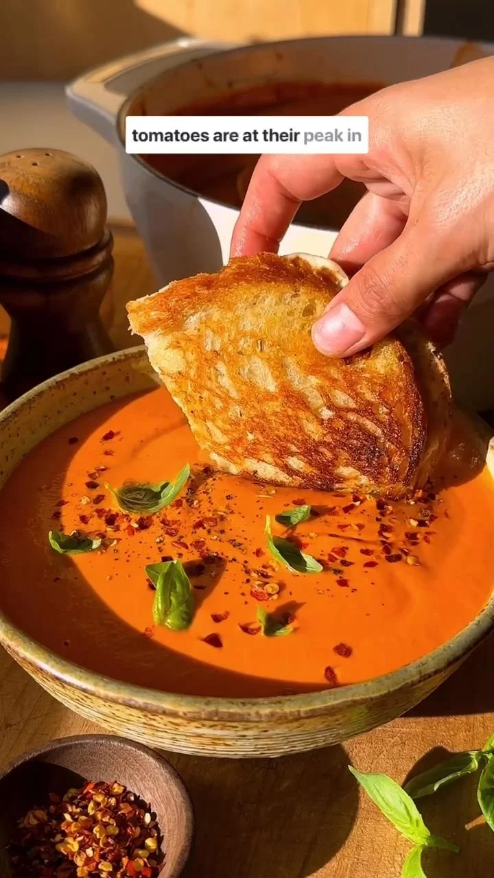Creamy tomato soup served with a golden grilled cheese sandwich