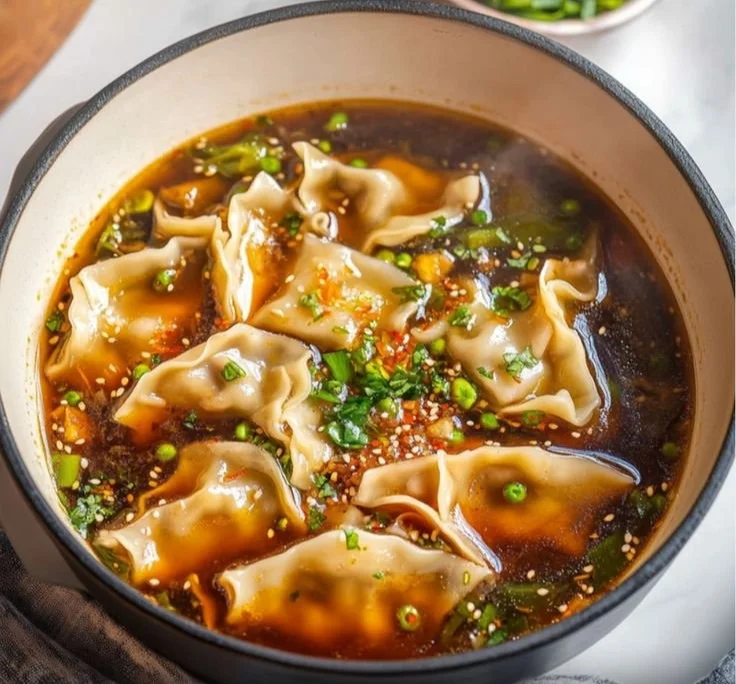 Bowl of delicious homemade Potsticker Soup with dumplings and herbs